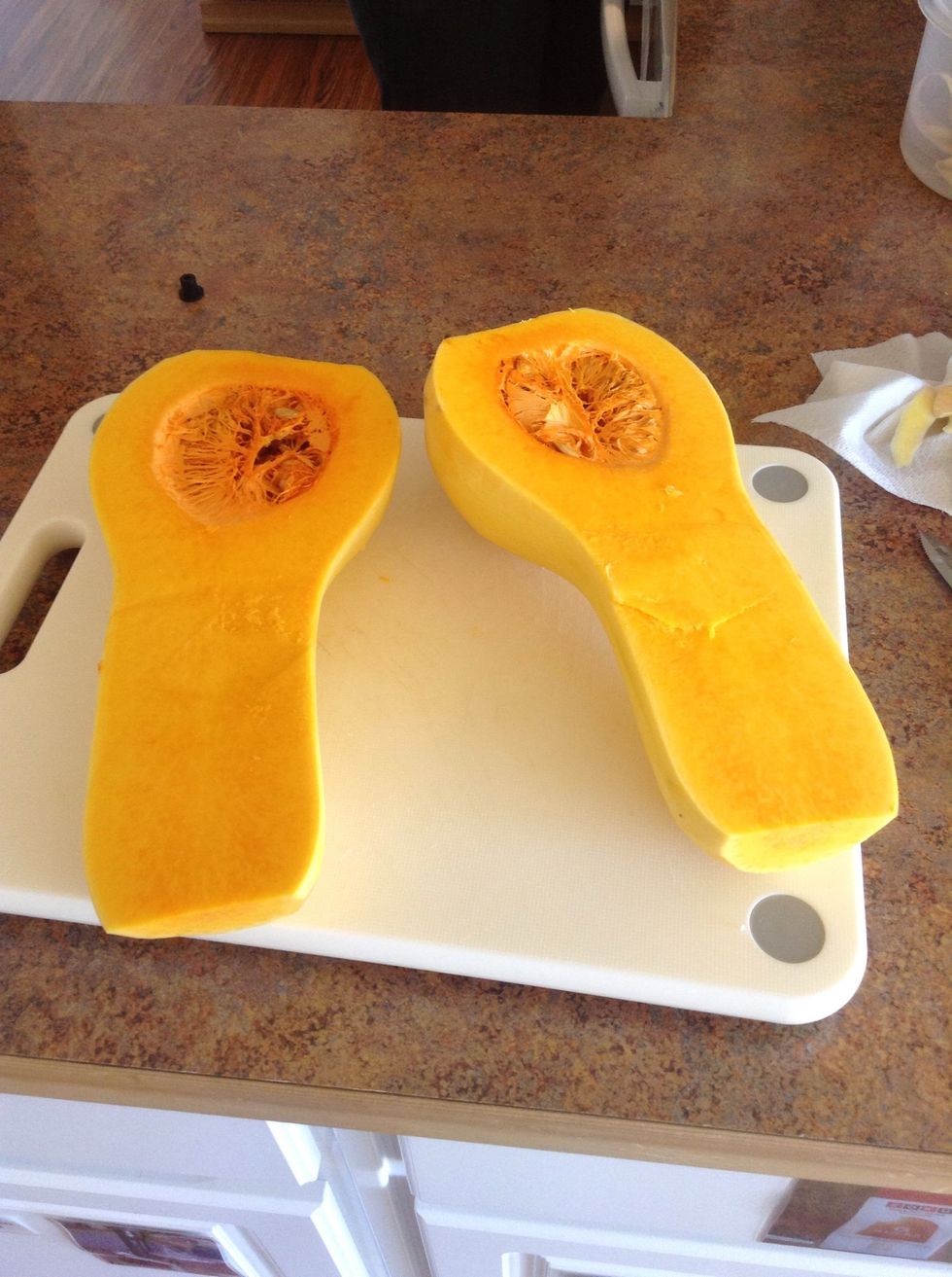 Carefully using cutting board and knife cut the butternut squash in half