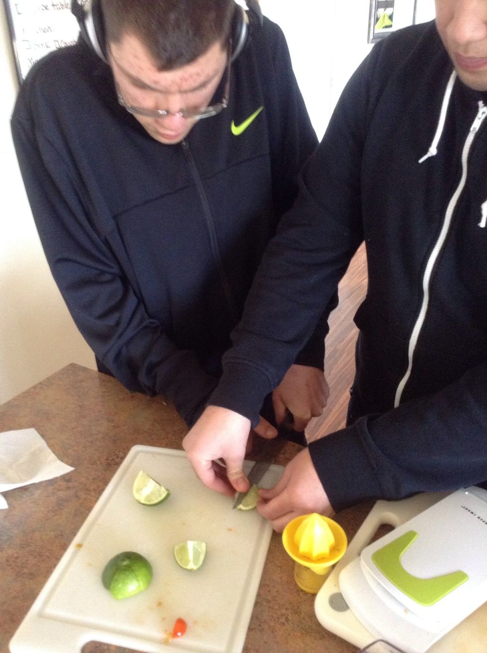 Carefully using cutting board and knife cut the lime into wedges