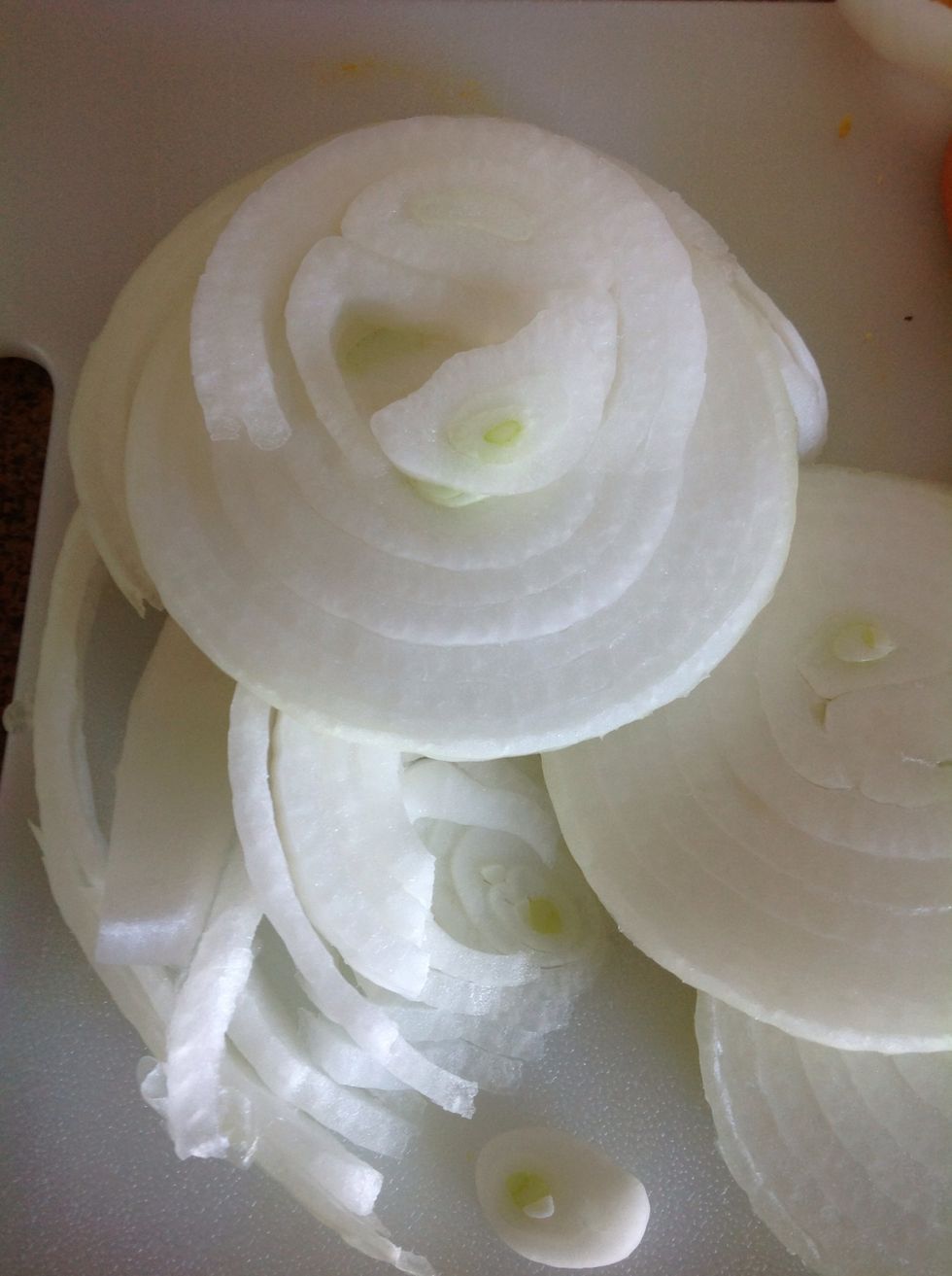 Carefully using cutting board and knife cut the onion into thin slices.