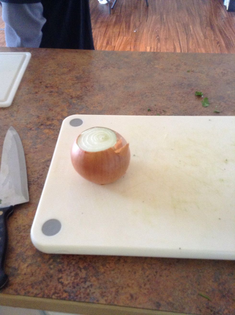 Carefully using cutting board and knife cut the top and bottom off onion