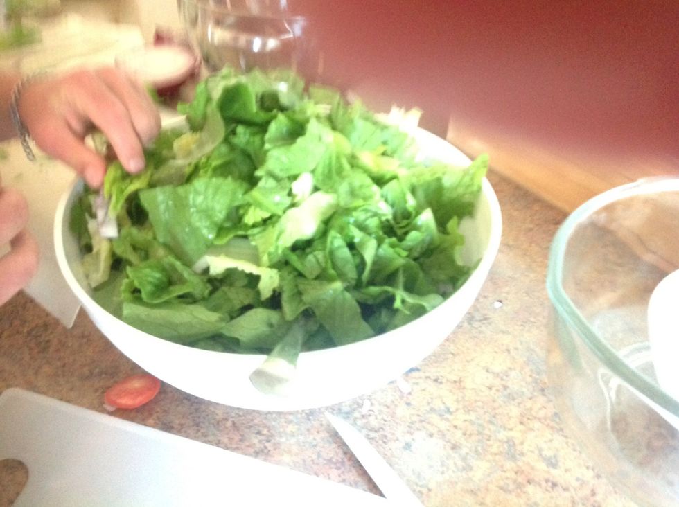 Carefully using knife and cutting board cut the lettuce into small pieces