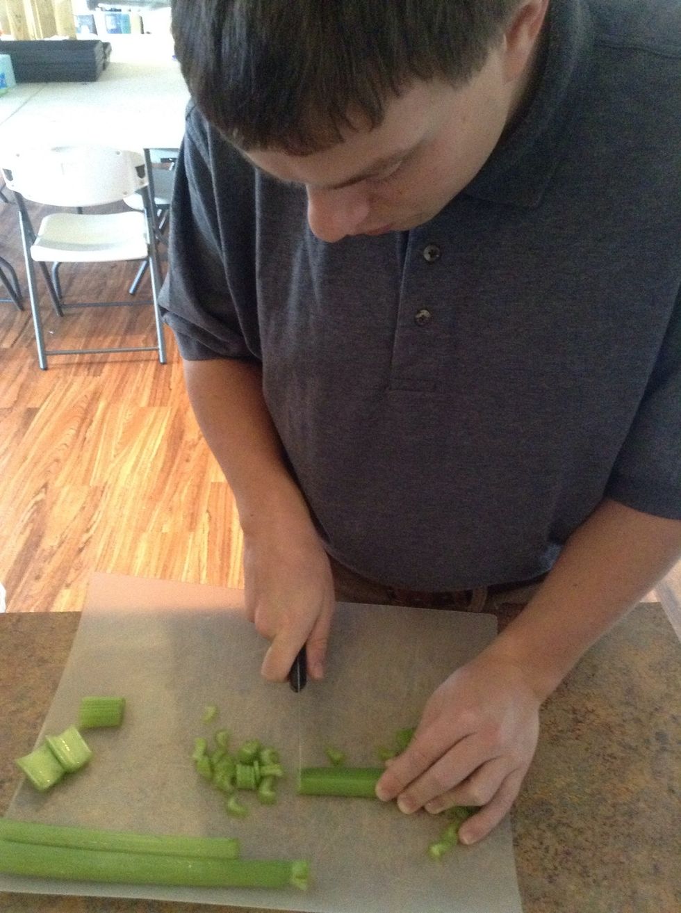 Carefully using knife and cutting board finely slice celery