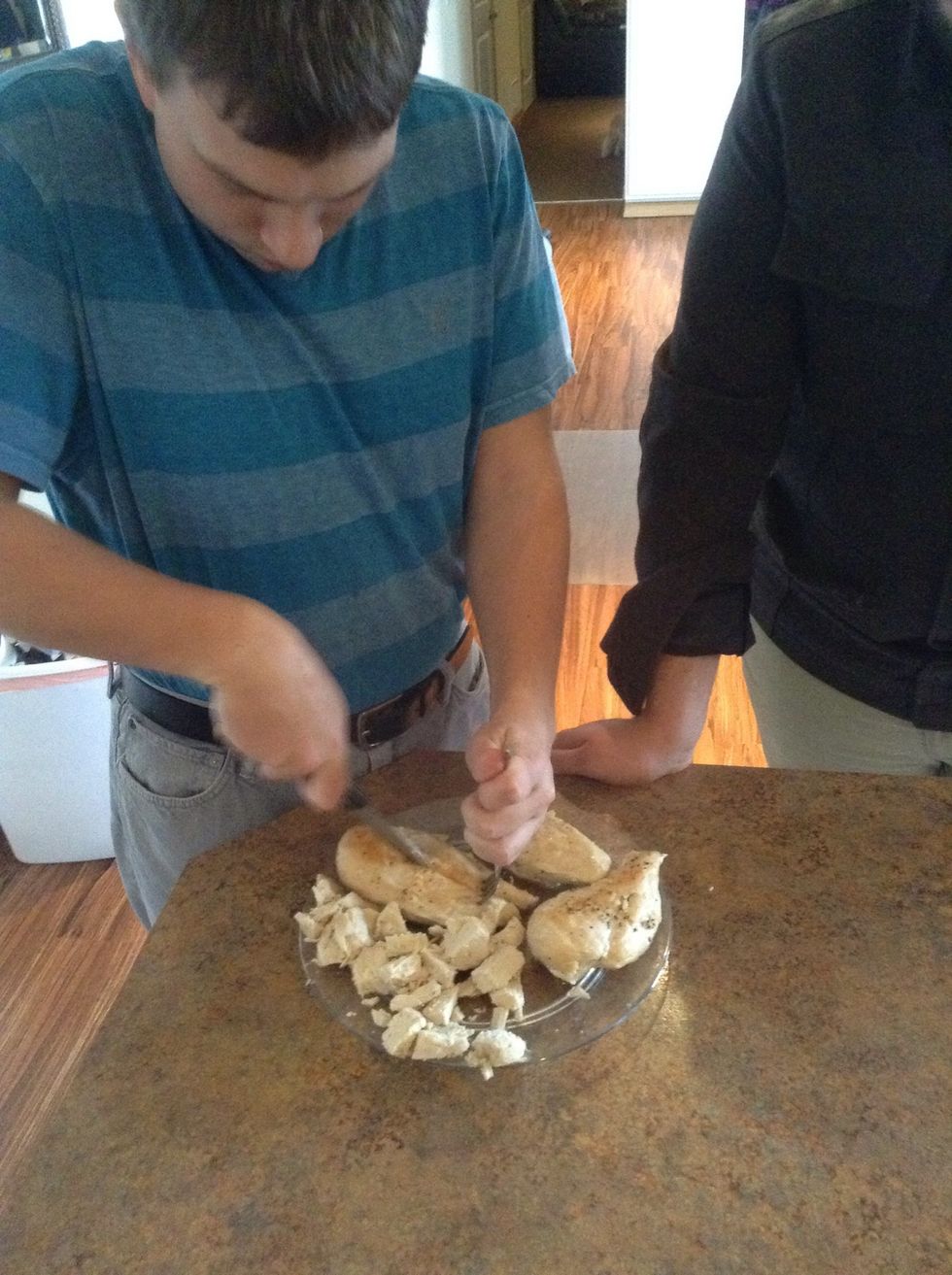 Carefully using knife and fork cut the chicken into bit sized pieces