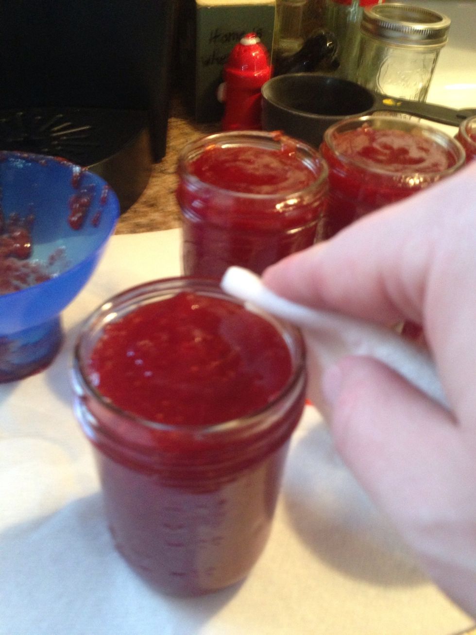 Carefully wipe the lip of the jar with the wet paper towel. This removes any spillage you may have, and cleans the lip for the lid to fit and seal properly.