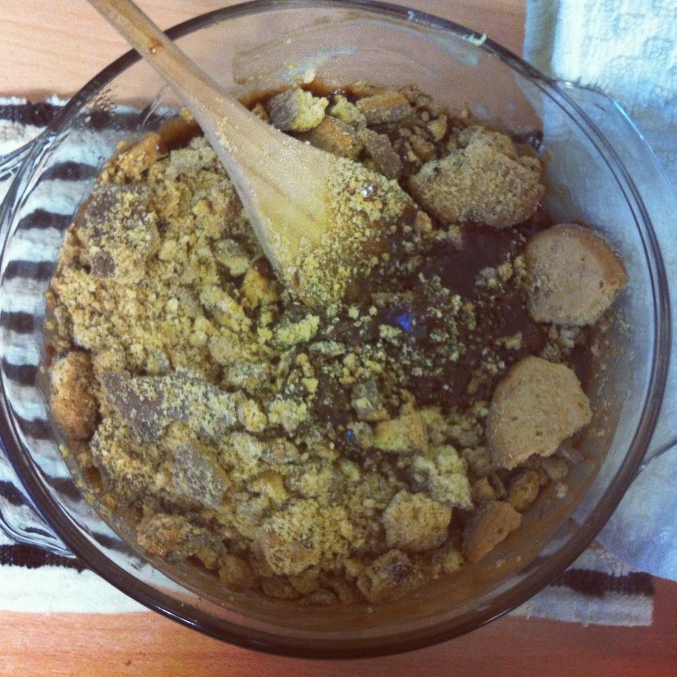 Carry the bowl to the work surface wearing oven gloves as it will be hot. (Leave the hob on and water boiling). Then quickly mix in the crushed biscuits...
