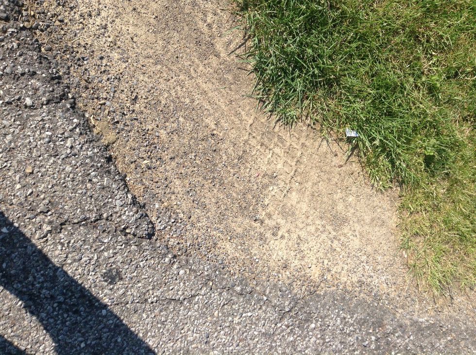 Cars have eroded the dirt and concrete. (Erosion)