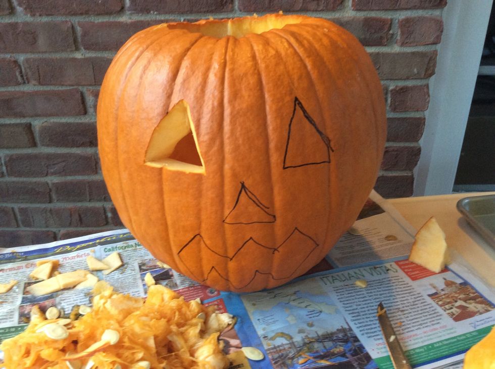 Carve the first eye out with the smaller knife.