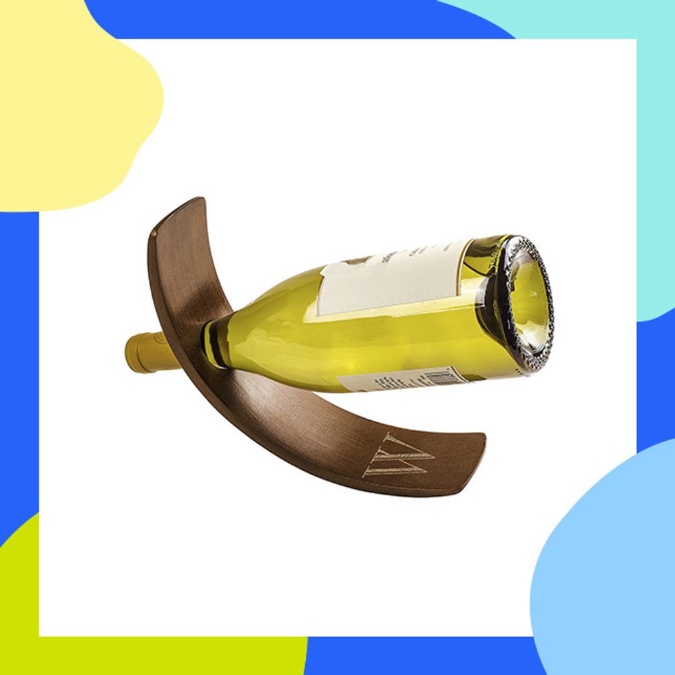 Cathy's Concepts Personalized Wood Balancing Wine Bottle Holder ($49.99): This balancing wine bottle holder is the perfect addition and it\u2019s basically a magician holding the bottle up like that.