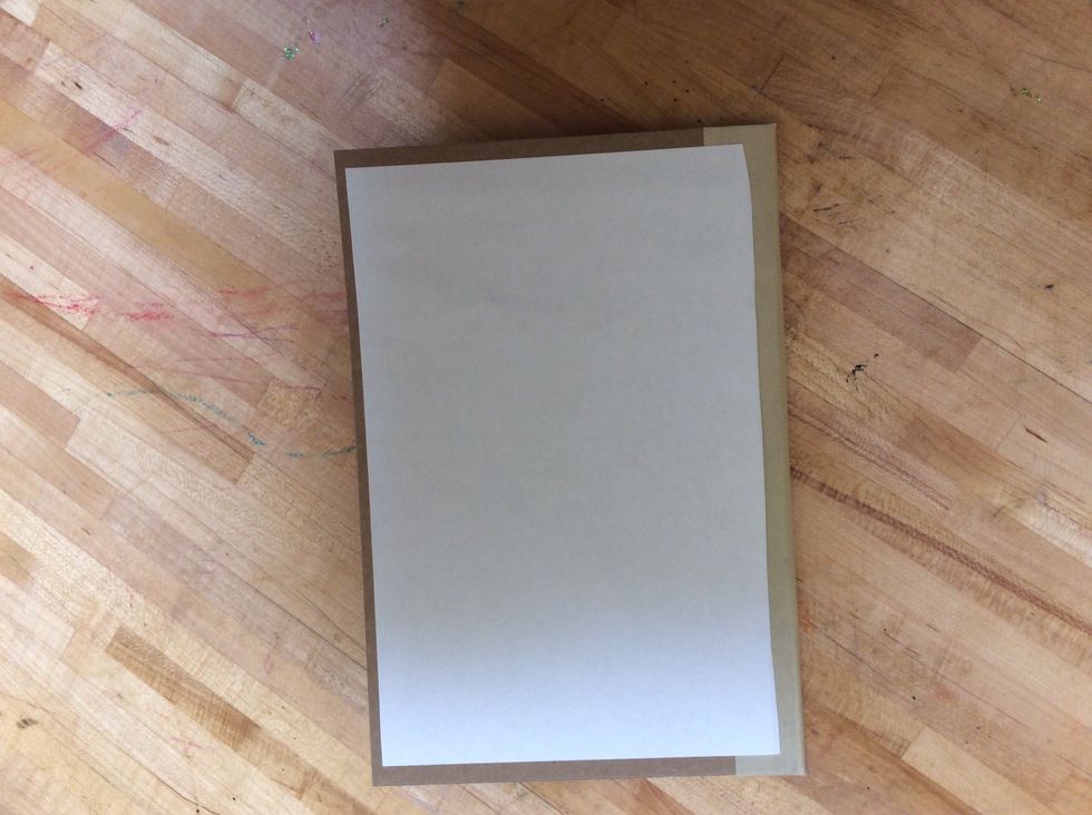 Center the piece of paper (glue side down) in the middle of the back of your book cover.  When you put it down rub and smooth the paper hard enough so that it sticks to the cardboard.