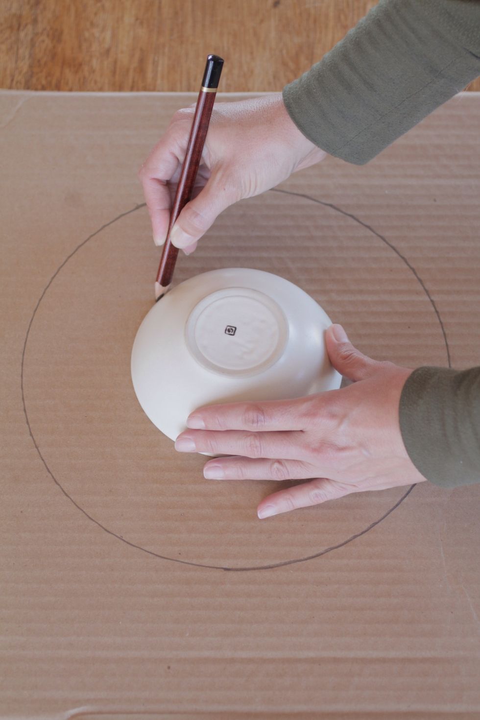 Center the small bowl in the circle you just drew, and trace a circle around the bowl.