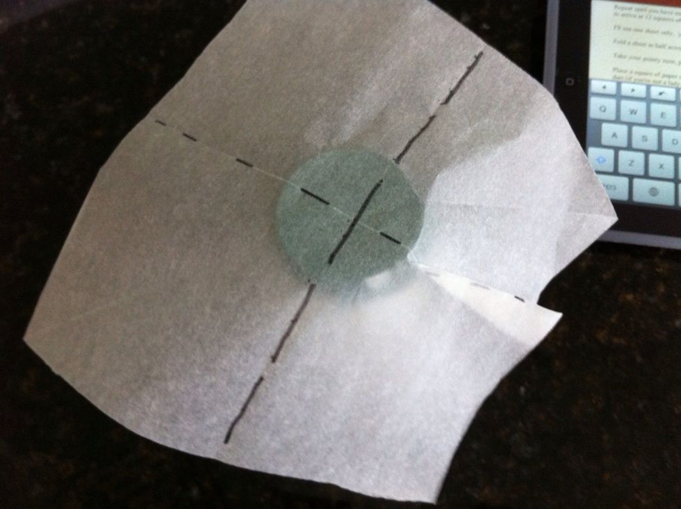 Centre your square over the inside mould (cup, salt container, whatever). Pinch and fold along one crease (see dotted line) until the paper is more or less flat to that side of the mould.