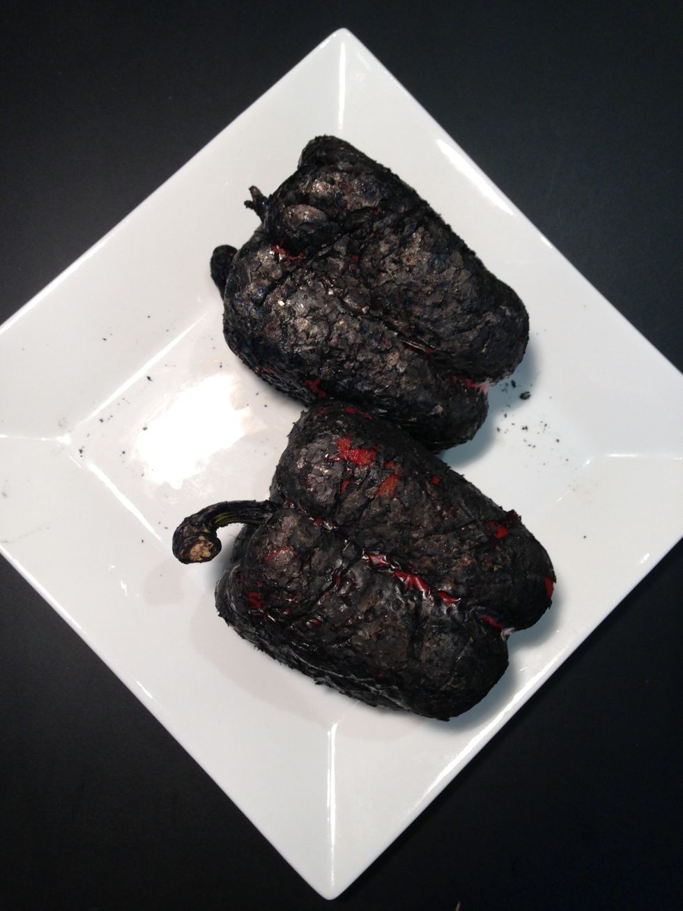 Charcoled on a Gas burner. If you prefer in the oven. Cut the bell pepper into halves and cook broil them on medium for 30 mins. Put them in a closed container. Take out the skin when cold.