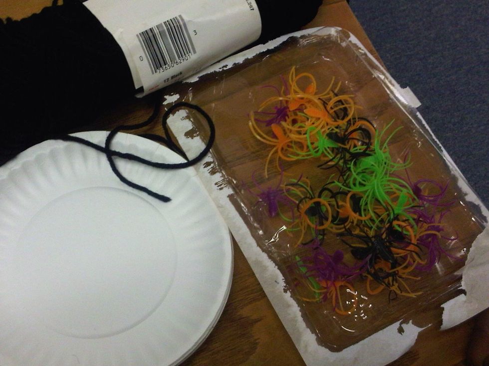 Cheap paper plates, any color yarn, plastic ring spiders, plus scissors