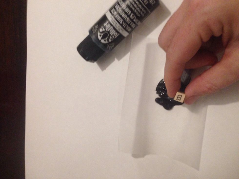 Choose a word or phrase to stamp out onto your dish. Dip the stamp into the black paint .