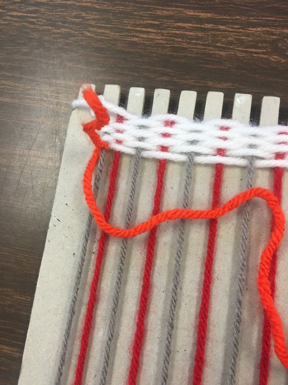 Choose your next color. Secure it by tying a tight small knot on the starting string of your base up at the base of your first color block.