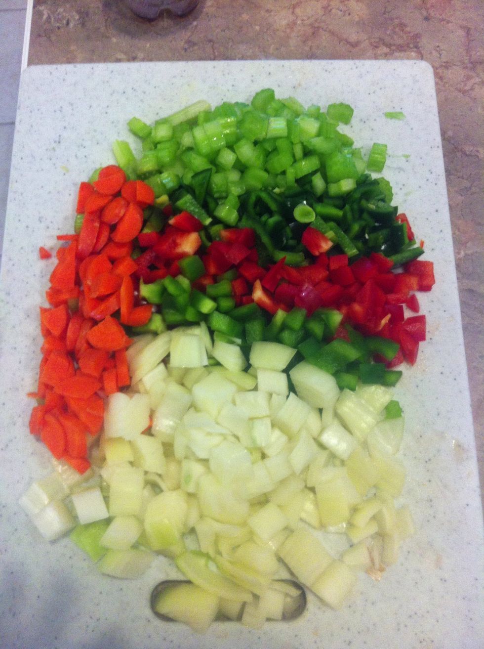 Chop 2 carrots, 1 poblano pepper, 1 medium yellow onion, 2 celery stalks, 1/2 red pepper and 1/2 green pepper.