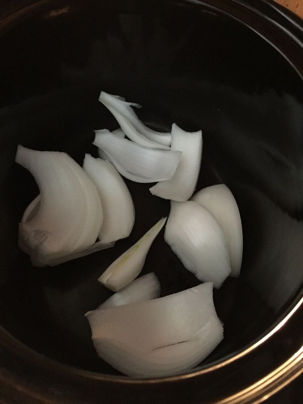 Chop an onion into large pieces and add to crock pot