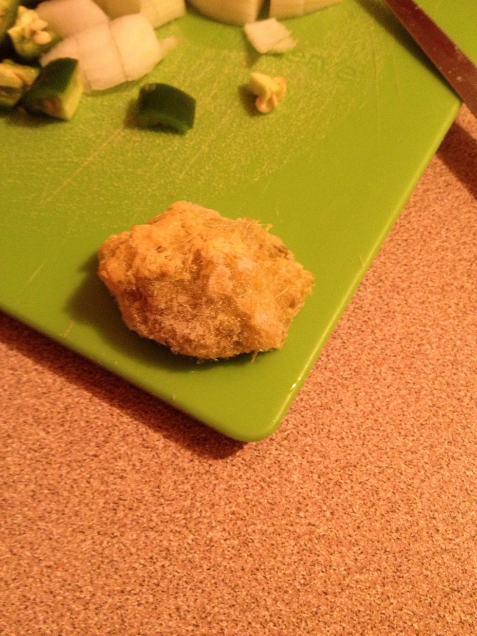 Chop and blend the ginger and garlic into a paste. This is what it looks like frozen (as Mom keeps it, pre-made). Add to pot. A green pepper can also be included in the paste.