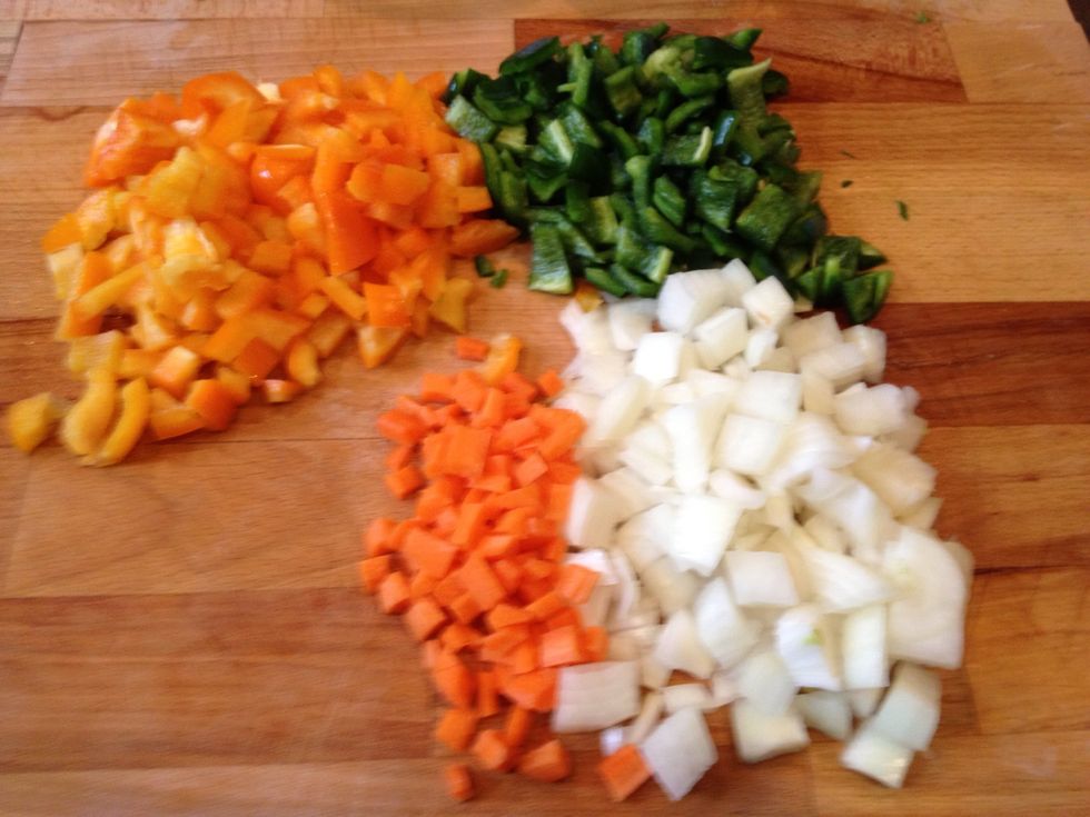Chop garlic, carrot,  onion, and peppers.