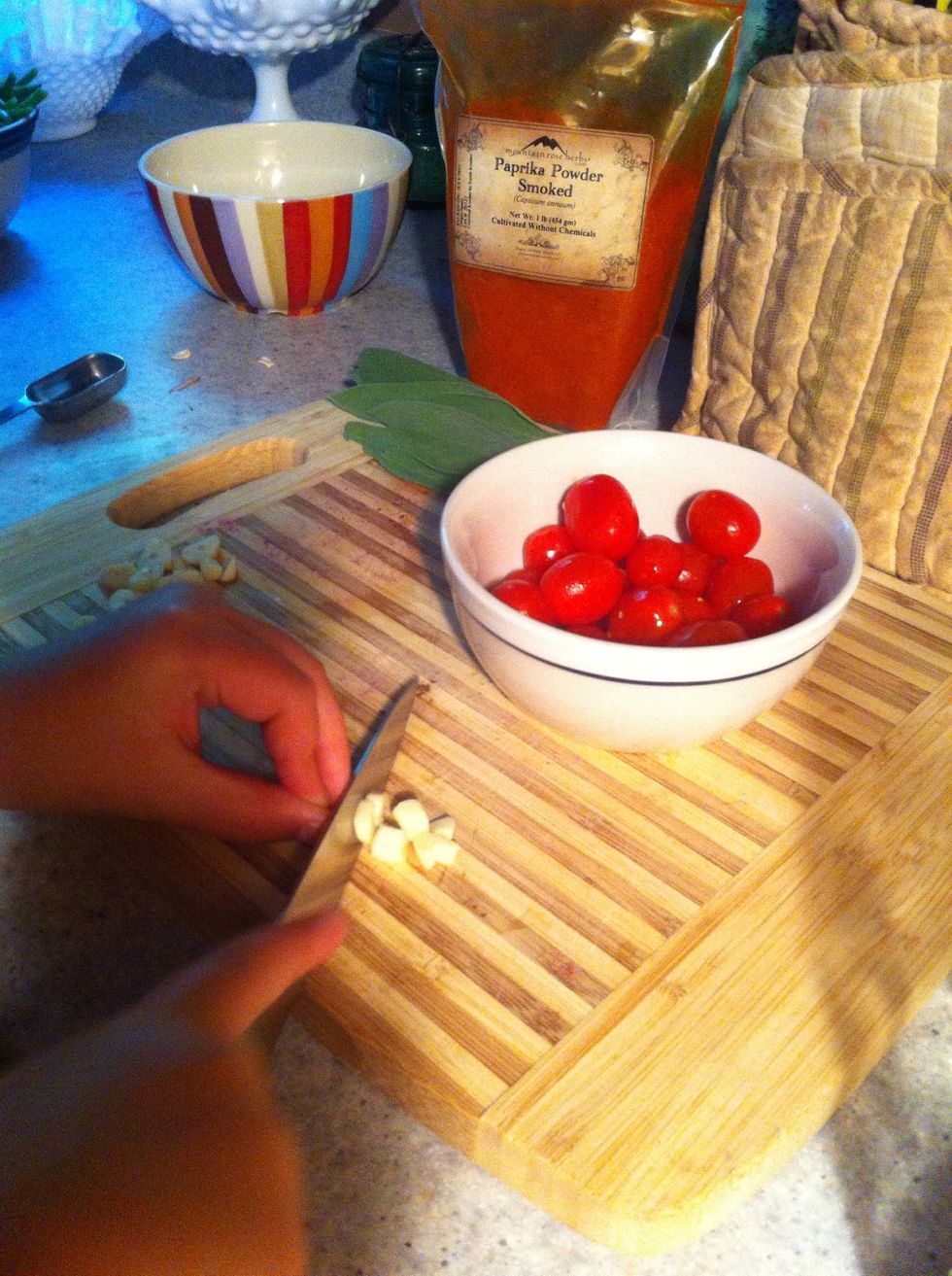 Chop Garlic into fairly large chunks, quarter Tomatoes and cut Sage in 1/8 strips...