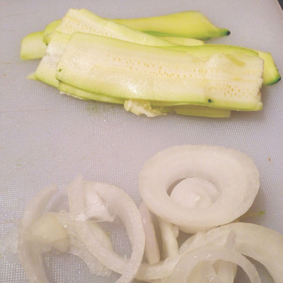 Chop onion and use mandoline to cut the zucchini into strips