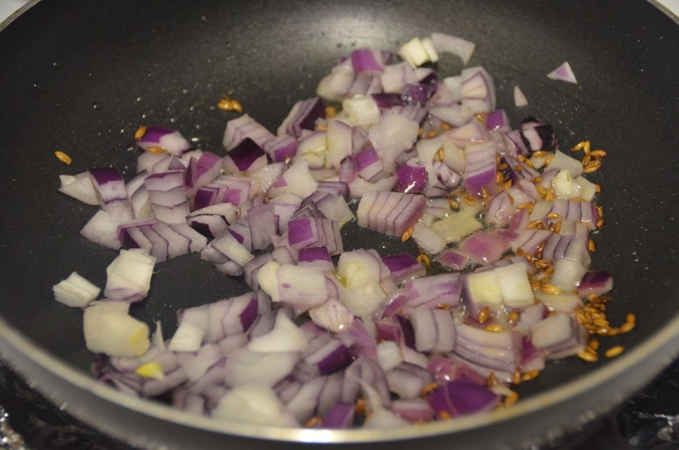 Chop onions, capsicum and garlic and keep aside. In a pan heat olive oil on medium high heat.. Add cumin seeds and onions. Saut\u00e9 for 2 minutes.