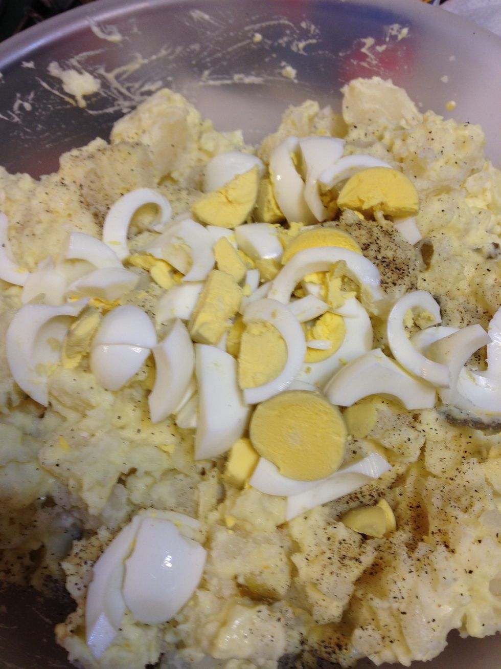 Chop the boiled eggs and mix. Add some salt and pepper mix all together. If too dry add more mixture to potatoes