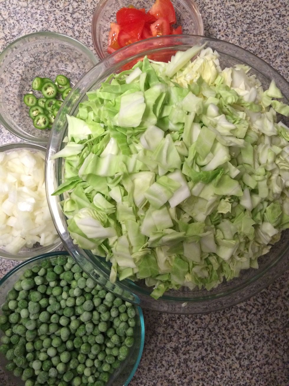 Chop the cabbage, onion, tomato and serrano pepper as shown. Keep aside with a cup of frozen peas.