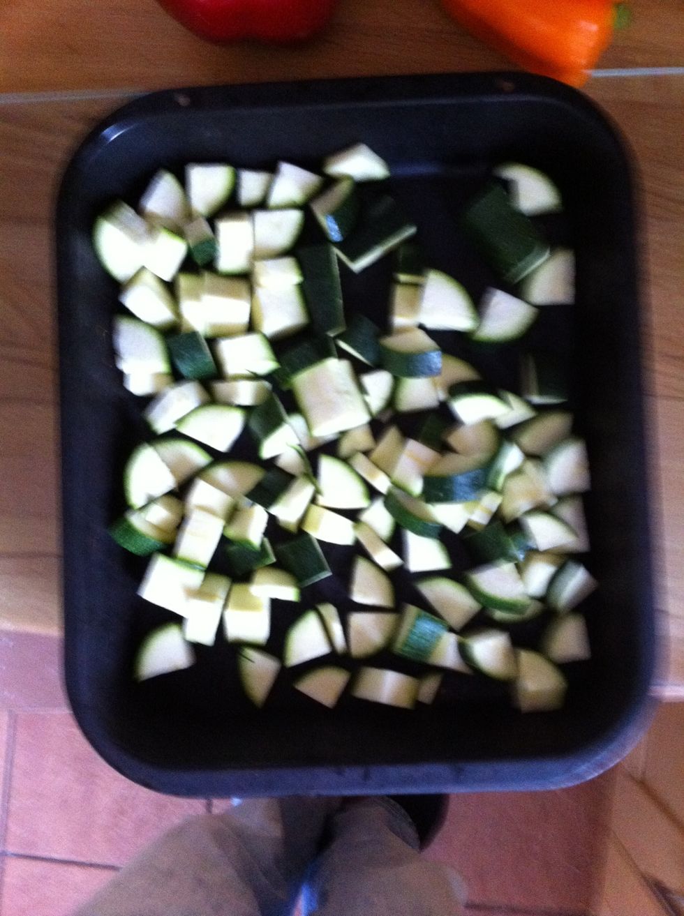 Chop the courgettes as small as you can then pop them into a roasting tray.