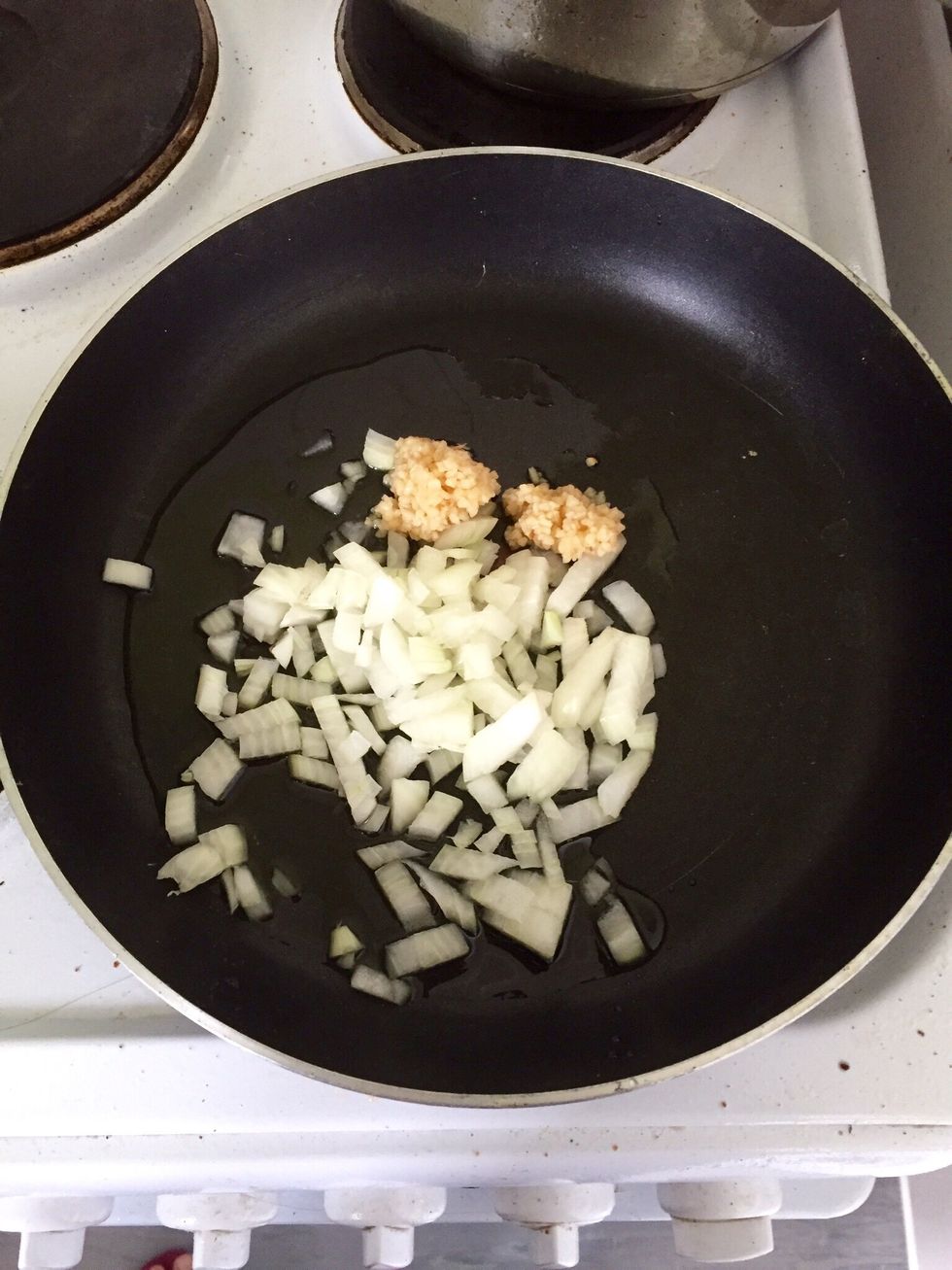 Chop the onion and add it to the pan with the garlic. I don't have a proper paella pan but any large one can work too