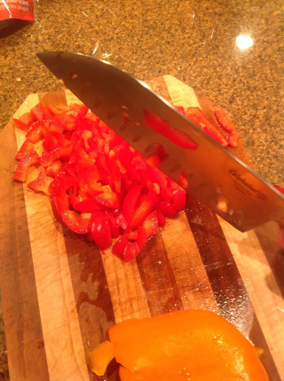 Chop the top of the pepper off with a knife, get the seeds out, then dice it up into small pieces. Repeat the same with the second pepper. Use a cutting board.