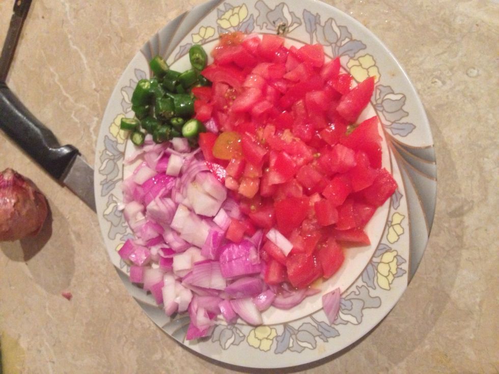 Chop tomato , onion and green hot chilli into small pieces.