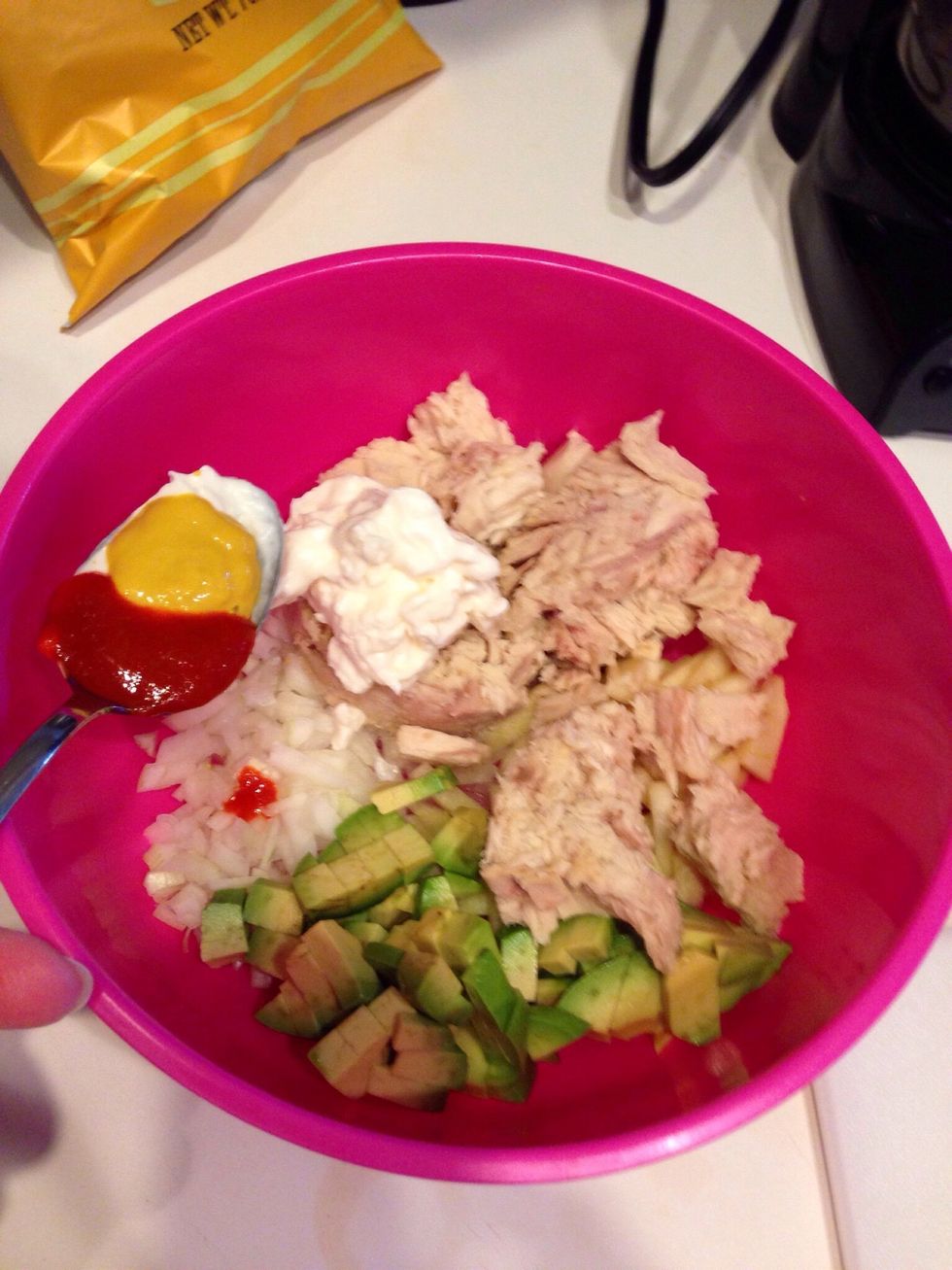 Chop up 1/2 or 1 whole avocado. Add the 2 cans of drained tuna fish. I used an actual spoon and added a heaping spoon of mayo, 1/2 of mustard, 1/2 of sriracha. You can add as much as you prefer.