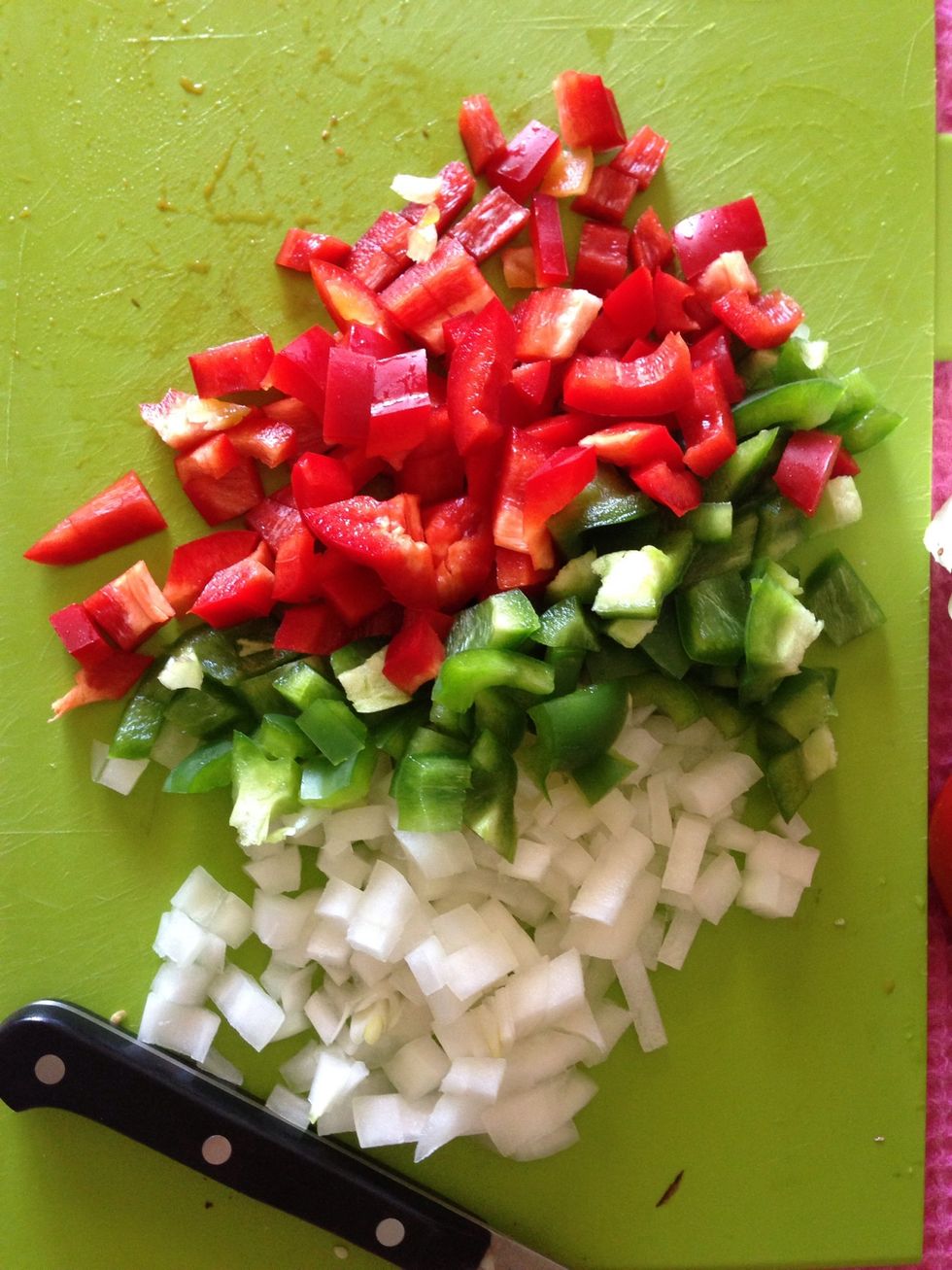 Chop your onion and bell peppers. Heat oil in a second pan and begin saut\u00e9ing.