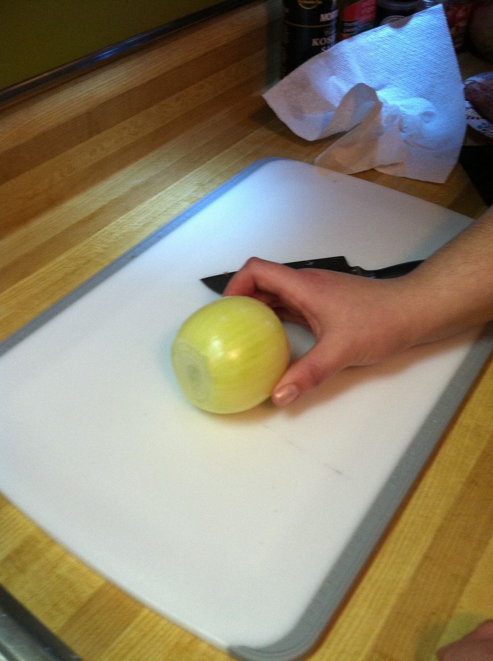 Chops ends off and remove outer layer of  onion skin.