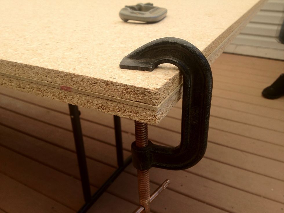 Clamp the three sheets of lumber you bought at Home Depot together on your work surface.