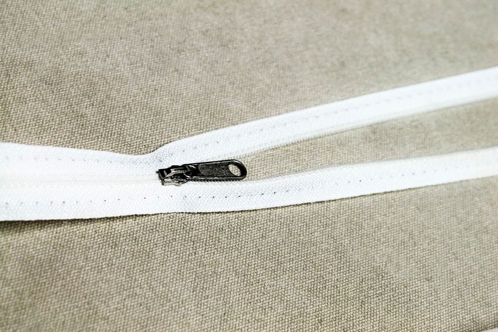 Clean all the old stitching off the lips of the zipper.  I use a wallpaper brush to remove all the old threads.  It works great.