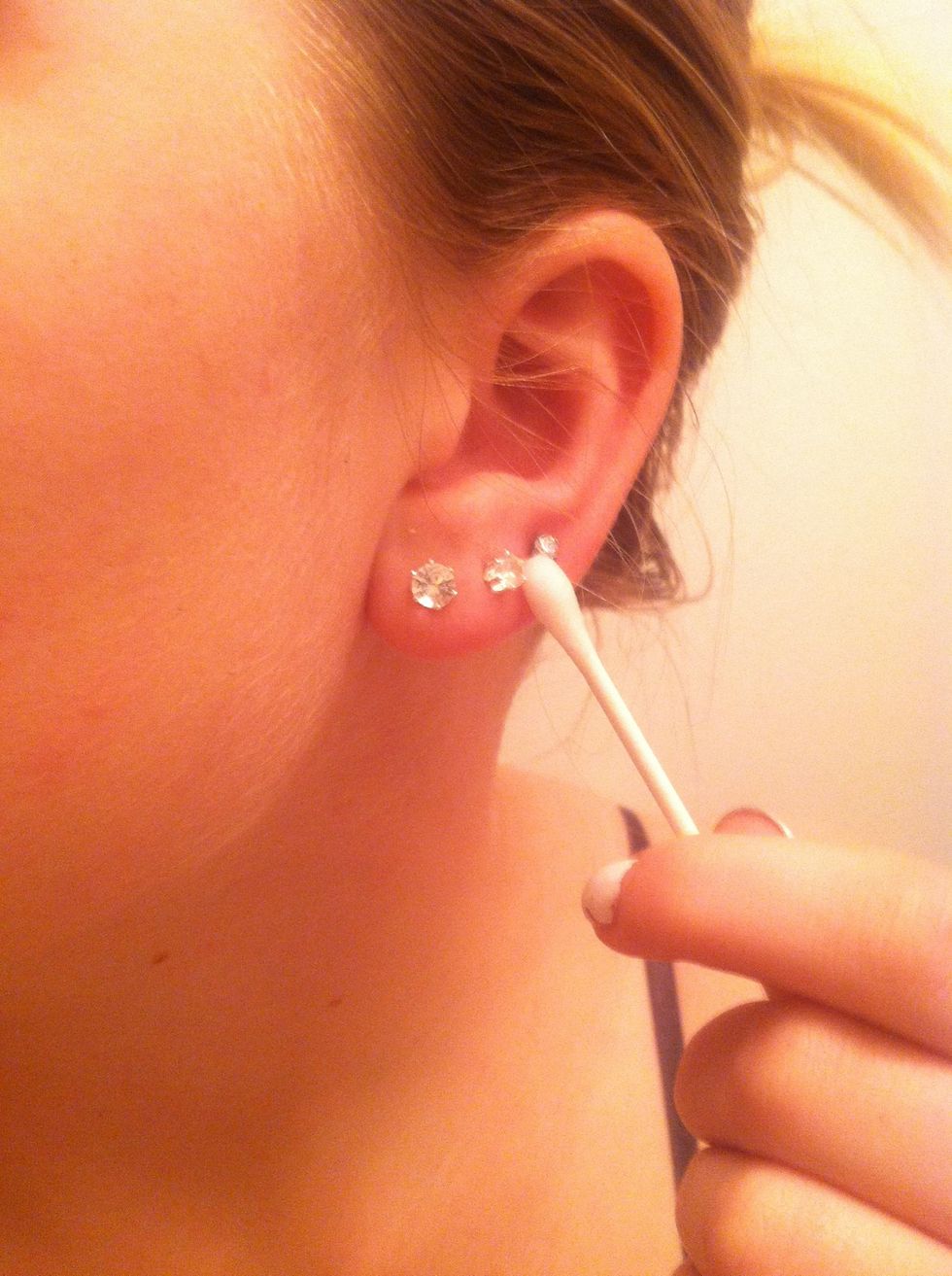 Clean around the piercing. The front and the back needs to be cleaned during this process.