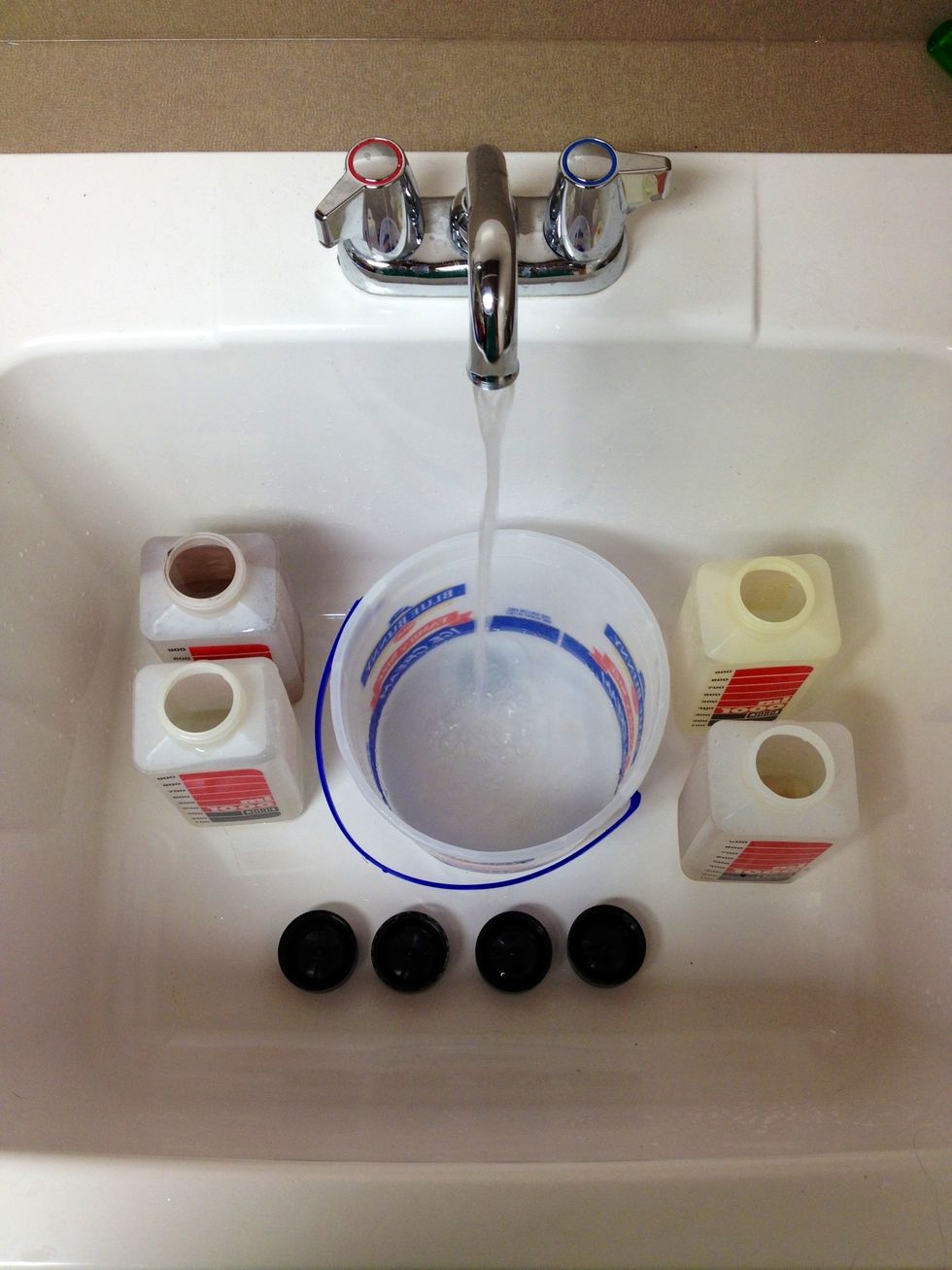Clean chemical bottles and fill bucket with hot water.