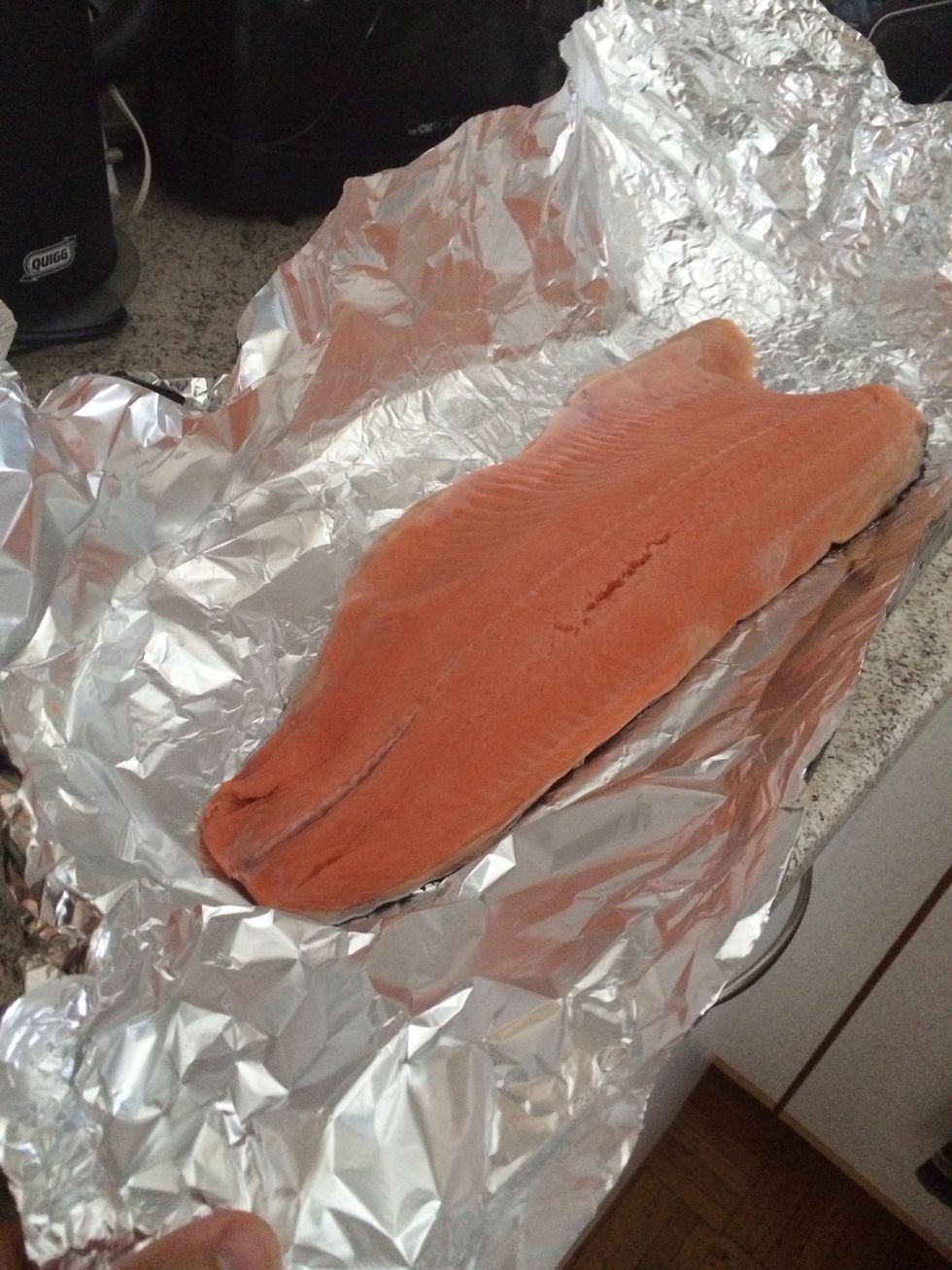 Clean salmon over water, then place it on tin foil big enough to cover it completely.