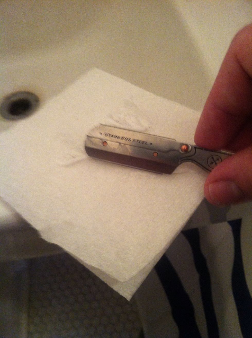 Clean the razor by whipping the blade away from you. When holding the razor in this position the motion would be from the bottom of the picture to the top.