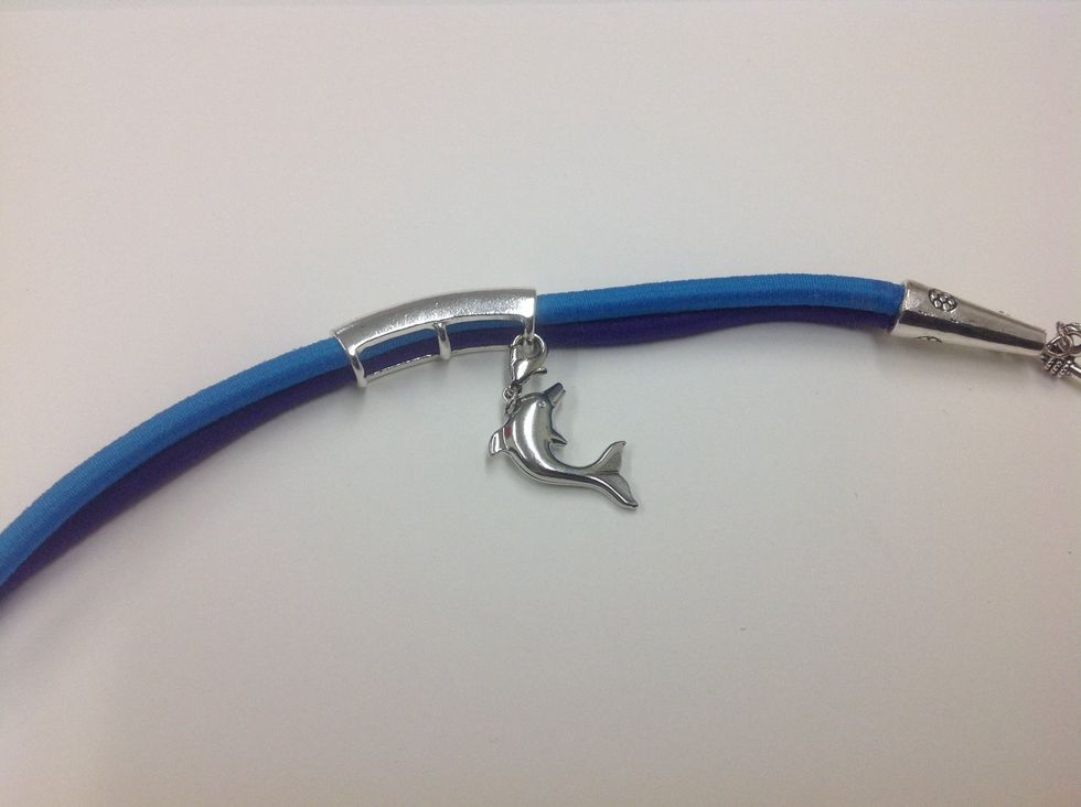 Clip the charm to one of the vertical bars on the back of the curved word tube.