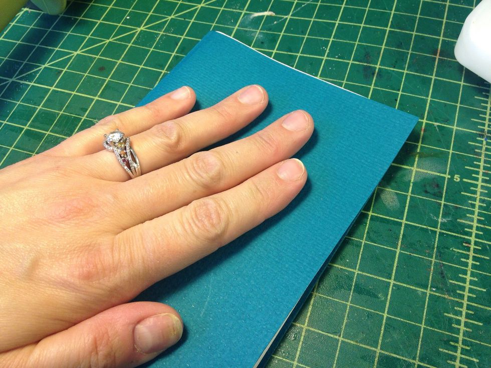 Close the book to adhere the first page to the cover. Repeat the glue on the last page and back cover.
