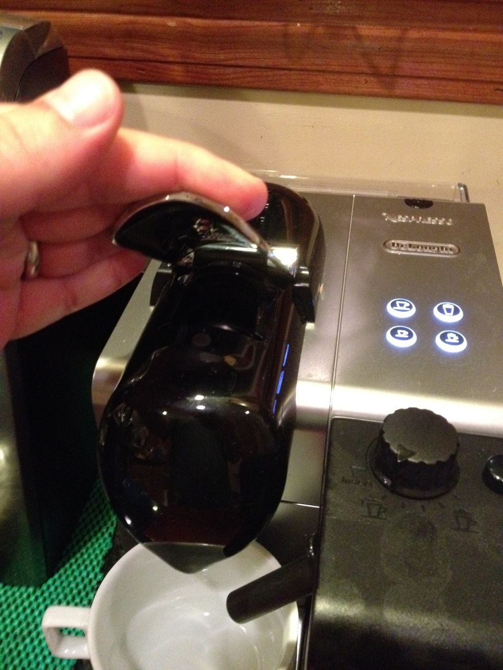 Close the door on top of the machine. If it sticks, it means the Nespresso capsule receptacle (which is located just behind where you put your coffee cup) needs to be emptied.