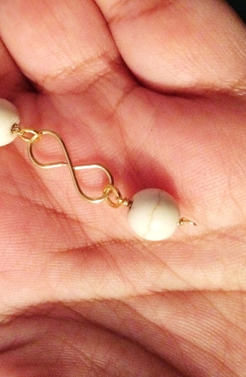 Close the jump ring in the same way and start putting all of the components together, connecting the wrapped beads with the infinity links using jump rings.