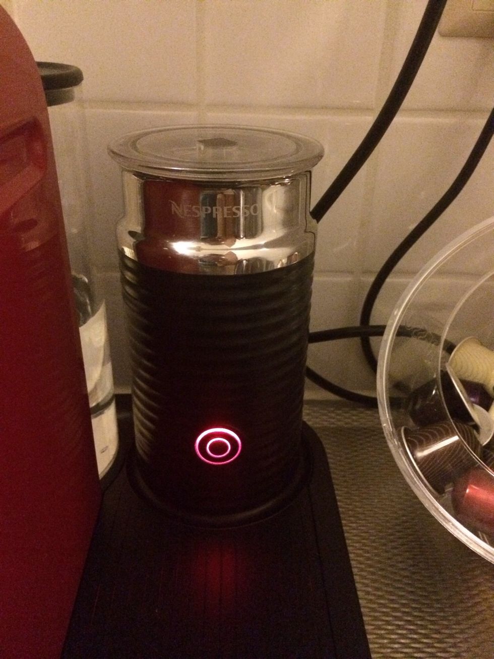 Close the milk frother, put it in place and turn it on by shortly pressing the on/off button. The button will light up and the milk will start frothing and warming up.