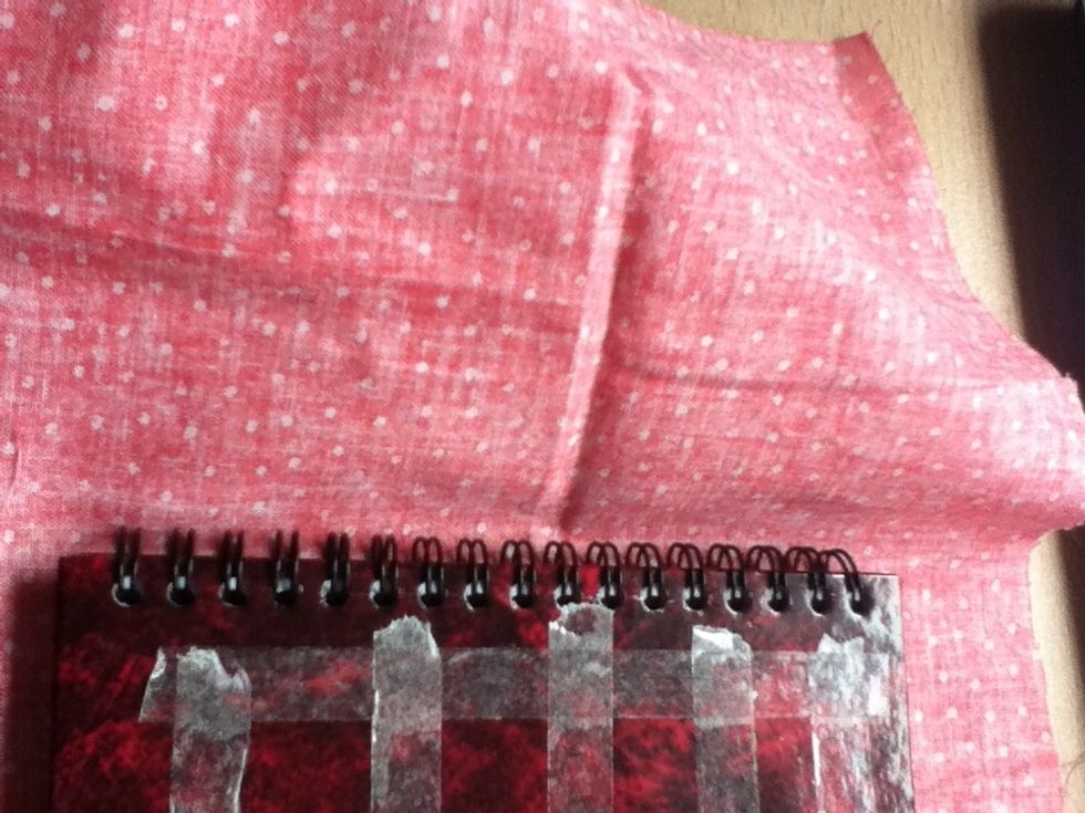 Close the notepad, and slowly place the fabric  down over the cover. (Be careful here- make sure there's enough room for the spiral binding to move, otherwise the notepad won't close!)
