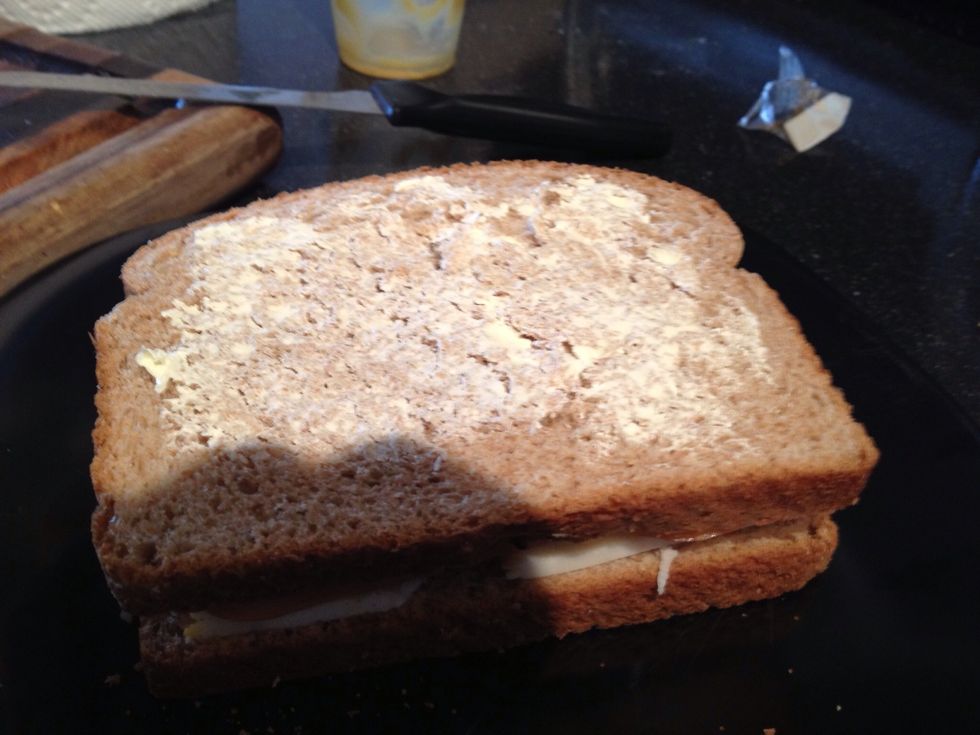 Close the sandwich and butter one side