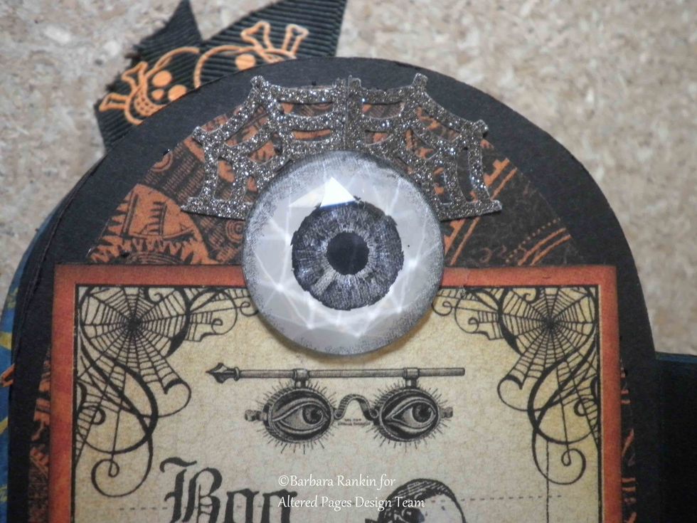 Close up of Glitz Design giant rhinestone eyeball, punched spiderwebs placed behind eye as eyelashes.