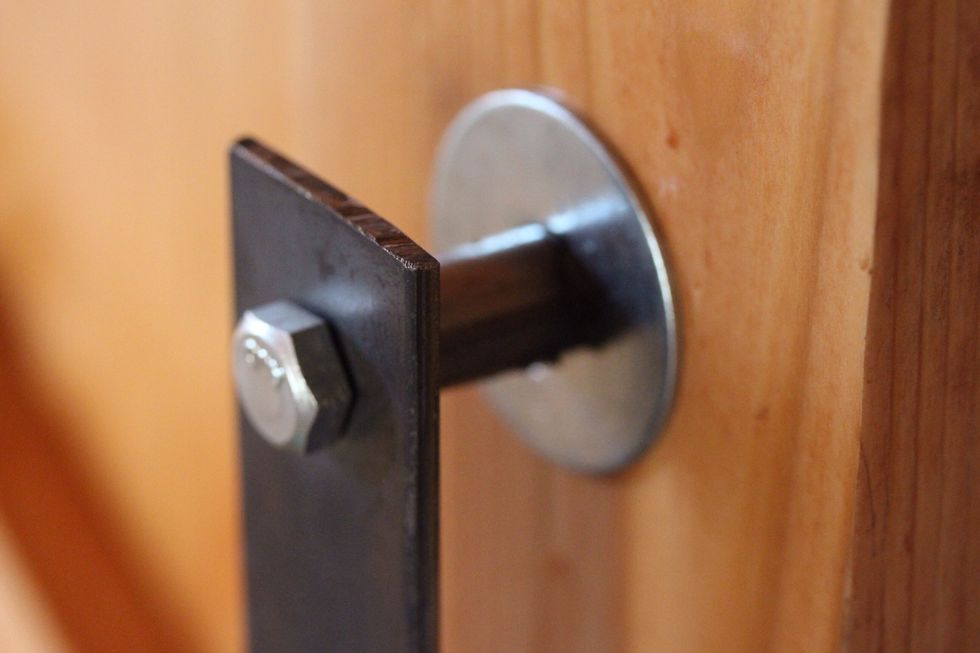 Close up of handle with bolt, washer and hollow steel support.
